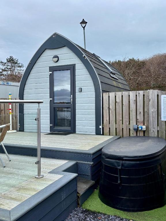 a small dome house with a wooden deck at The Midi Pod in Aberystwyth