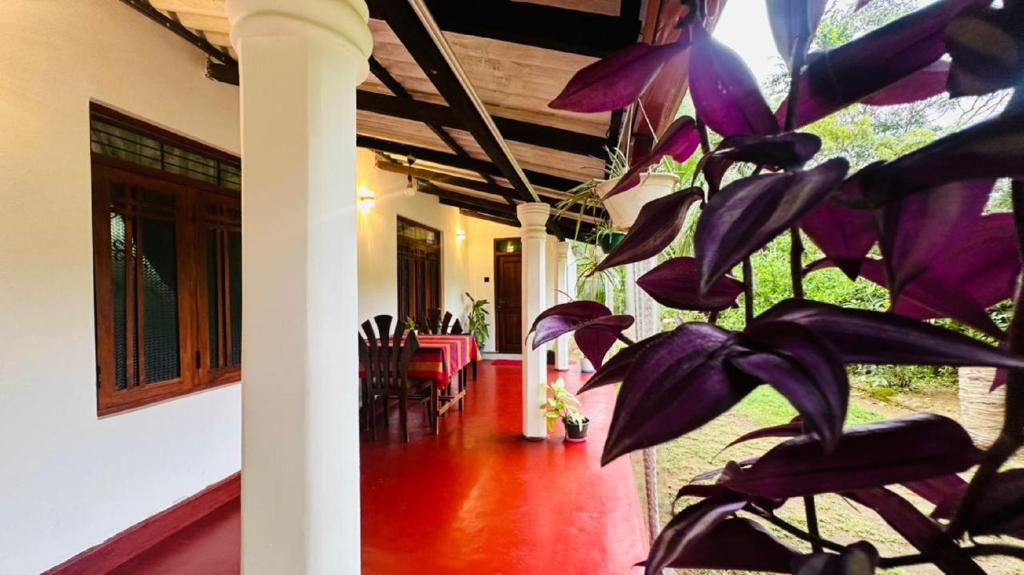 a house with a purple plant in the hallway at Sigiriya Hidden Home Stay in Sigiriya