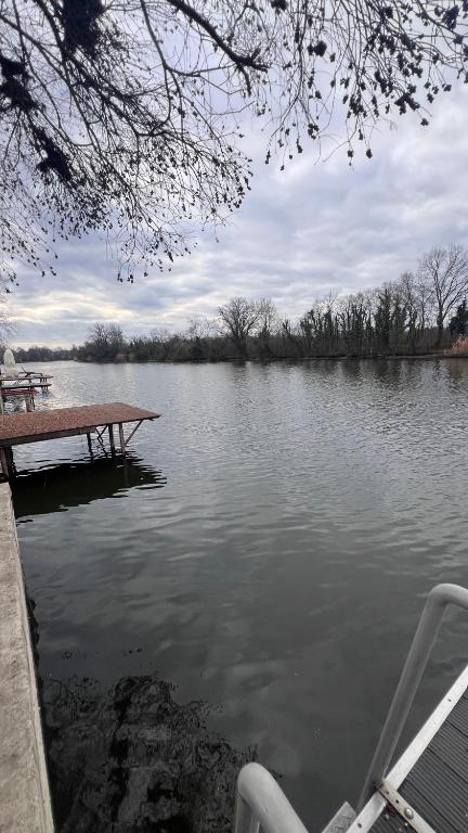 a view of a lake with a wooden dock at Baba néni nyaralója in Szarvas