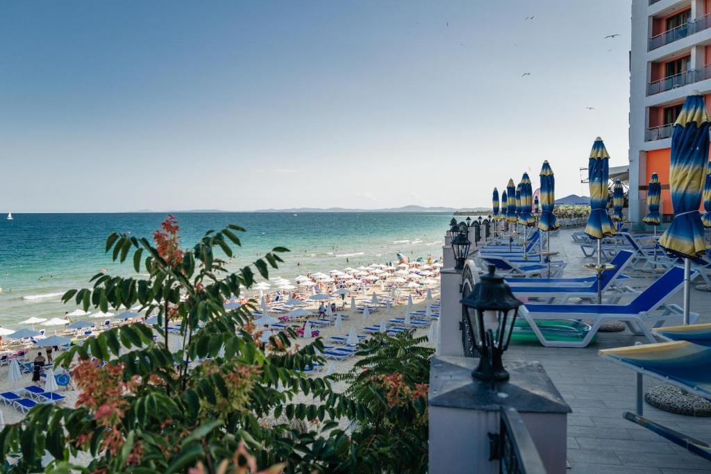 a beach with chairs and umbrellas and the ocean at Mirage Collective in Nesebar