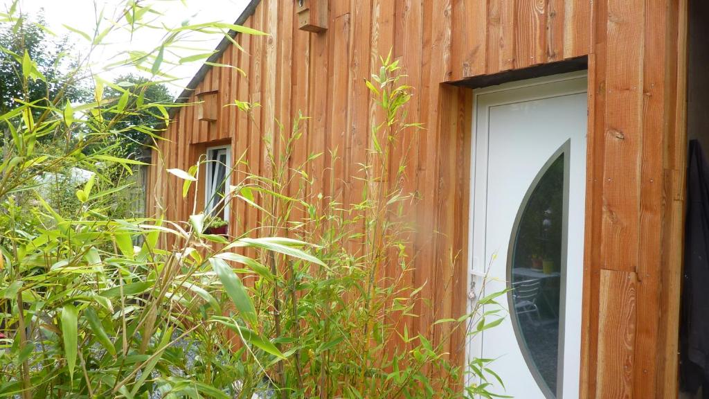a wooden building with a door and some plants at Gite D'étape de roslaye in Gourin