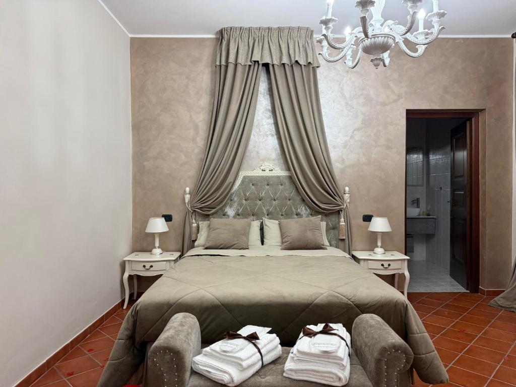 a bedroom with a large bed with a chandelier at La Dimora in Morino