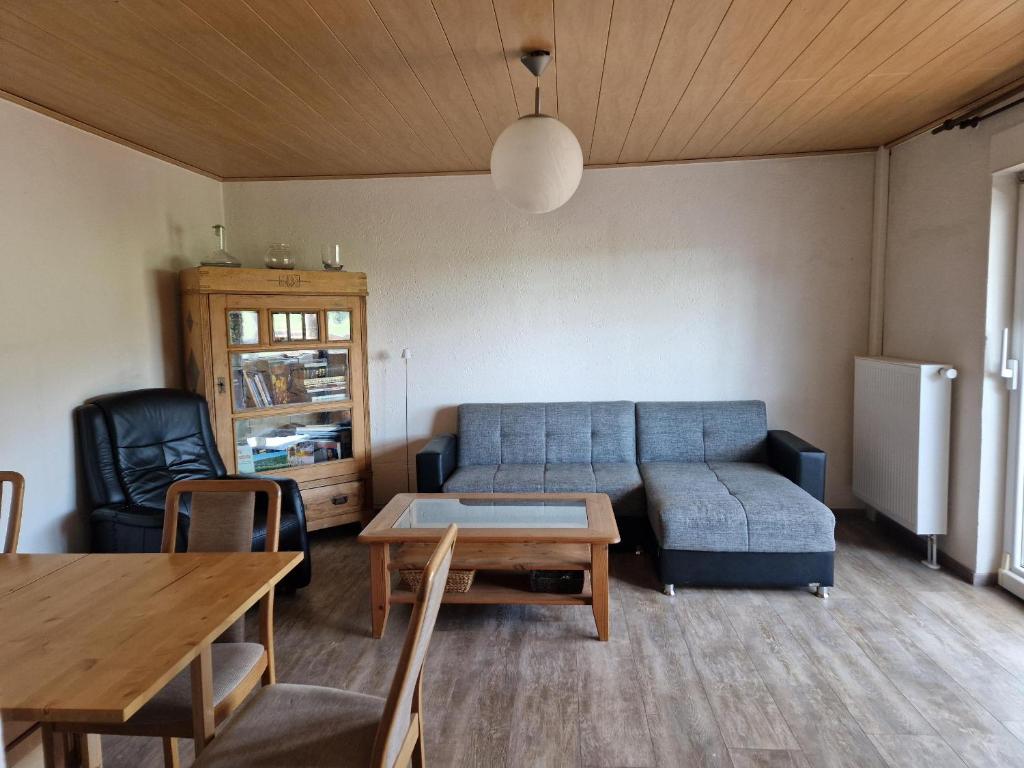 a living room with a blue couch and a table at Ferienwohnung Saller in Weißenbrunn