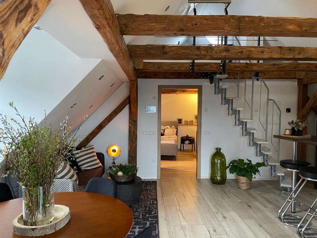 a living room with wooden ceilings and a staircase at Rosenzauber-Seeromantik in Weißenstadt