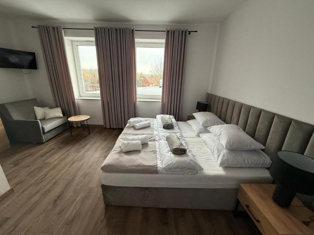 a bedroom with a large bed and a chair at Hostel Granat in Czekanów