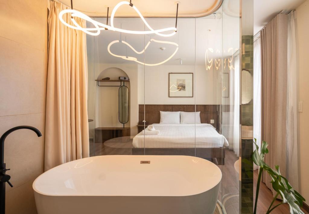 a bathroom with a bath tub and a bed at Saigon Maison 1988 BUI VIEN Centre in Ho Chi Minh City