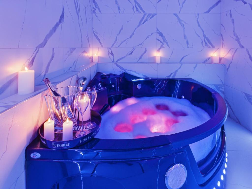 a jacuzzi tub with two candles and candles at Jacuzzi LoveAparts Marki Romantic Getaway in Marki
