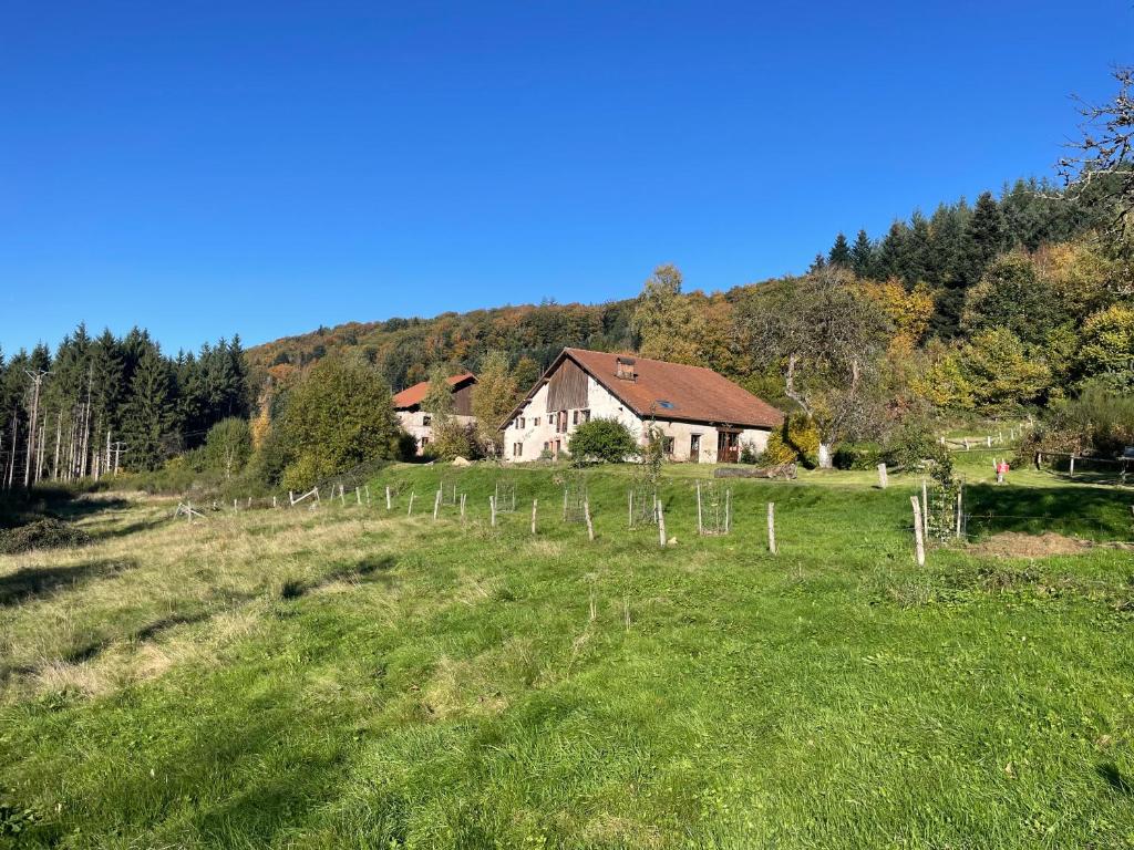 una casa en un campo con una valla en La Hutte, en Tendon