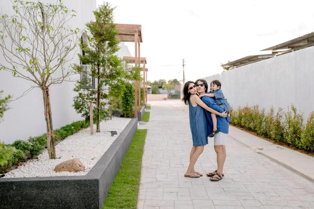 a woman in a blue dress hugging a baby at Merry Holmes Resort Hatyai in Ban Tha Sae