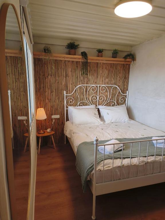 a bedroom with a bed in a room with plants at הzimער של ביטון in Merhav Am