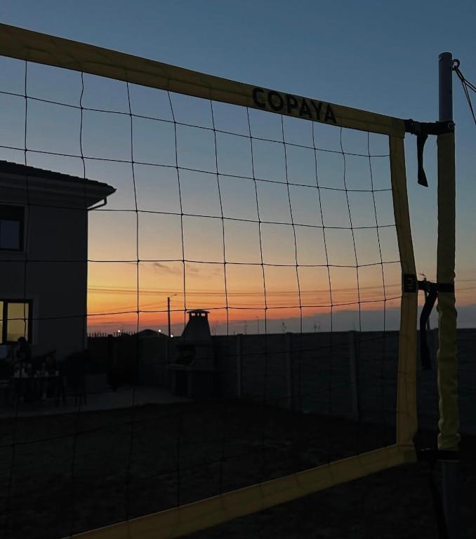 a view of the sunset through a fence at Villa D'amici in Moşniţa Veche
