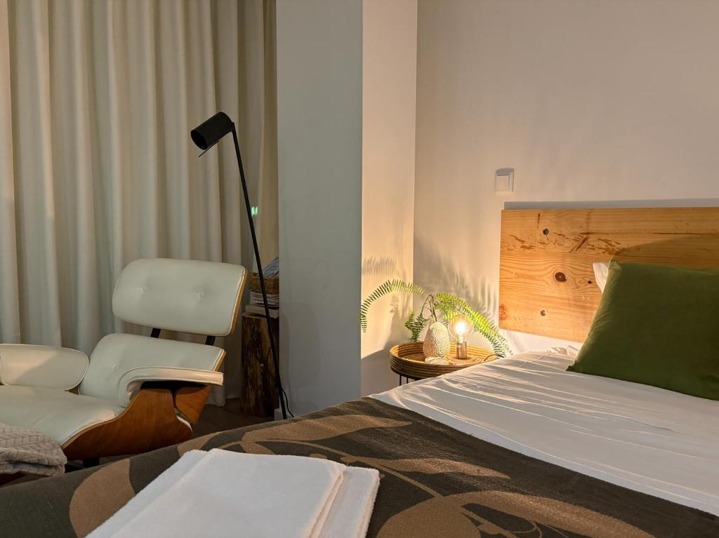 a hotel room with a bed and a chair at Autor Guesthouse in Vila do Conde