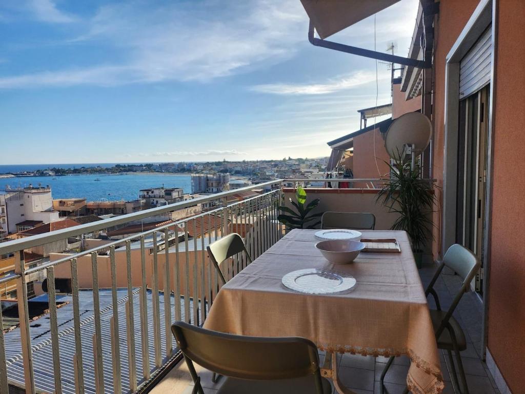 a table on a balcony with a view of the water at Serenity Naxos Vacation Home in Giardini Naxos