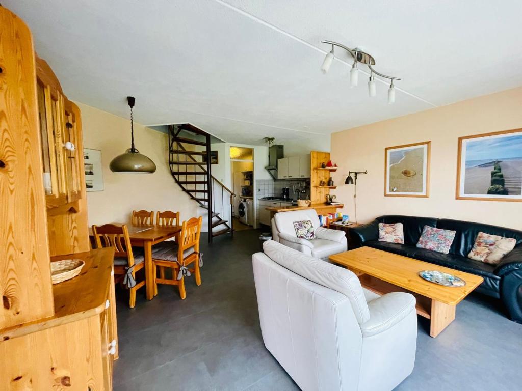 a living room with a couch and a table at Heggerank 80* in Nieuwvliet