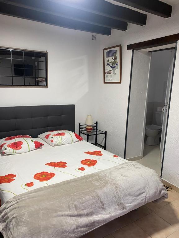 a bedroom with a bed with red flowers on it at Gite de Sainte Gemme in Sainte-Gemme