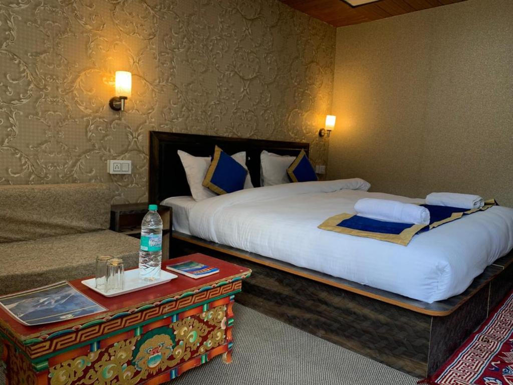 a hotel room with a large bed and a couch at Hill Side Cabin, Pangong in Spangmik