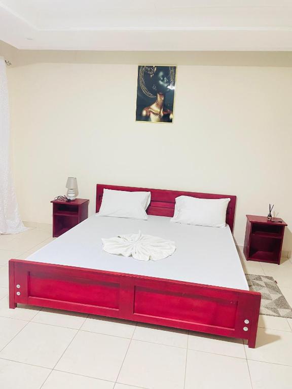 a bedroom with a large bed with a red frame at Bulle d'Or PREMIUM in Libreville