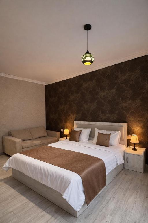 a bedroom with a large bed and a couch at Urban Nest old Tbilisi hotel in Tbilisi City