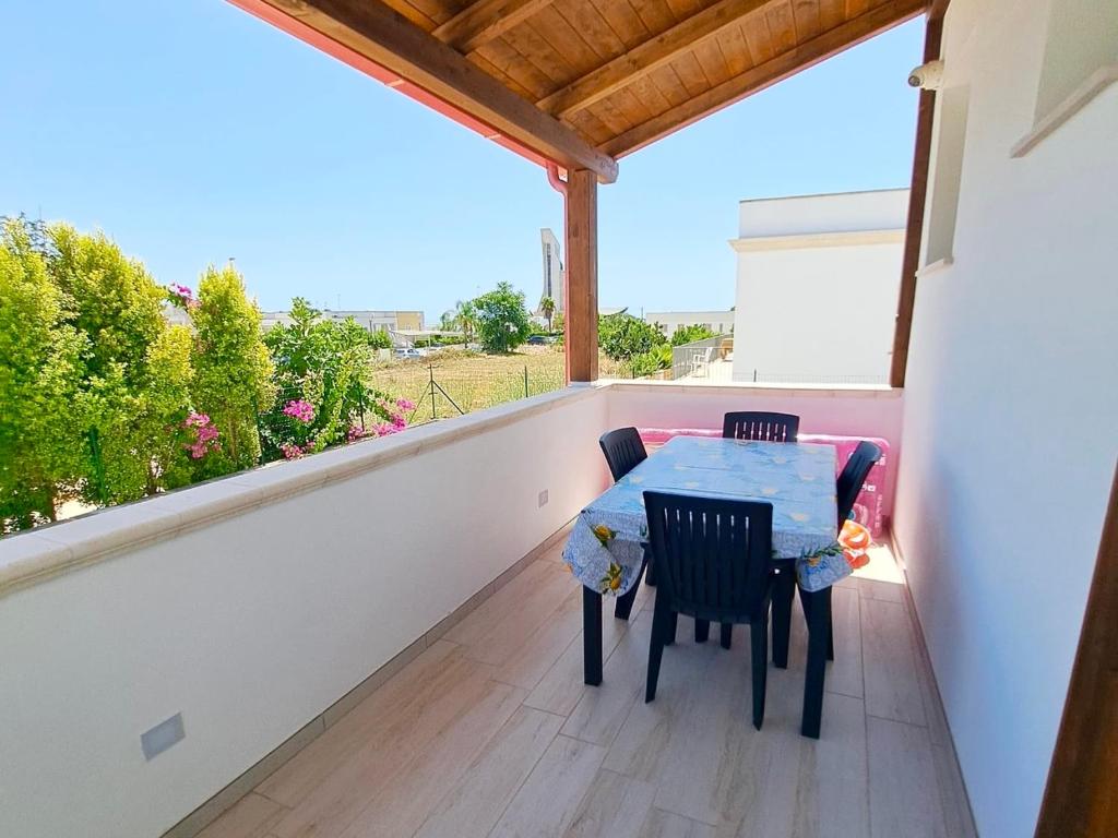 a balcony with a table and chairs on it at Serene Sea - Holiday Homes in Marina di Pescoluse