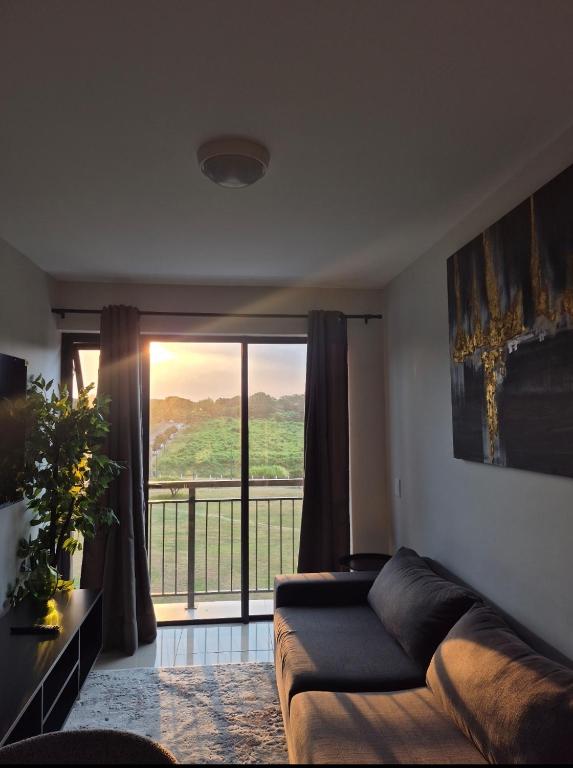 a living room with a couch and a large window at Tettey Haven Millennial in Durban