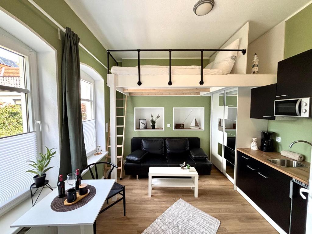 a living room with a couch and a loft bed at Haus OstseeWelle - Kleine Perle in Dahme