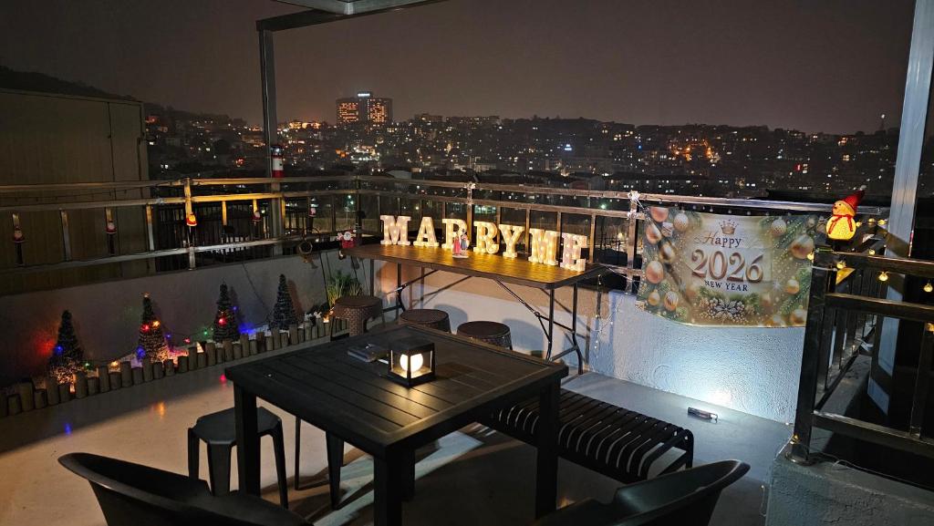 a balcony with a table and a happyativity sign on it at BinsHeim HBC - Seoul's Aesthetic Stay with the best Night view Rooftop in Seoul