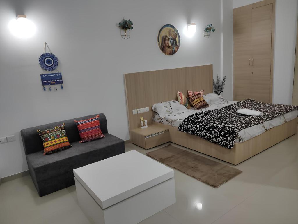 a bedroom with a bed and a couch at Shivaya Homes in Chhatikara