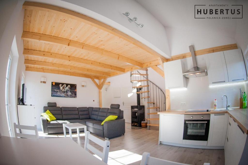 eine Küche und ein Wohnzimmer mit einem Sofa und einem Tisch in der Unterkunft Hubertus in Polanica-Zdrój