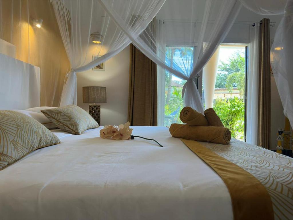a large white bed with two stuffed animals sitting on it at ADWO Lodge in Ngaring