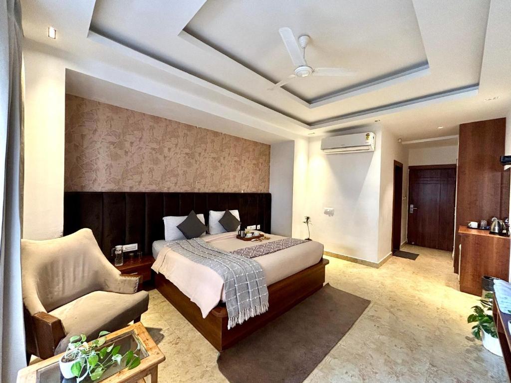 a bedroom with a bed and a couch and a chair at Vyom Boutique Hotel by Aramah in Rishīkesh