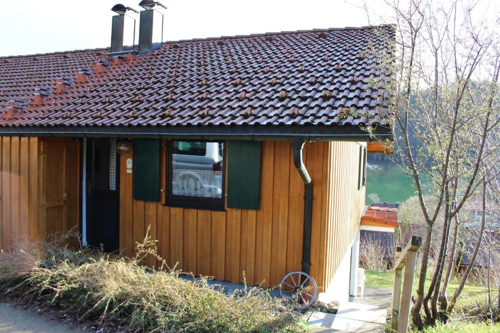 a small wooden house with a dog in the window at Ferienhaus Alpkönig in Missen-Wilhams