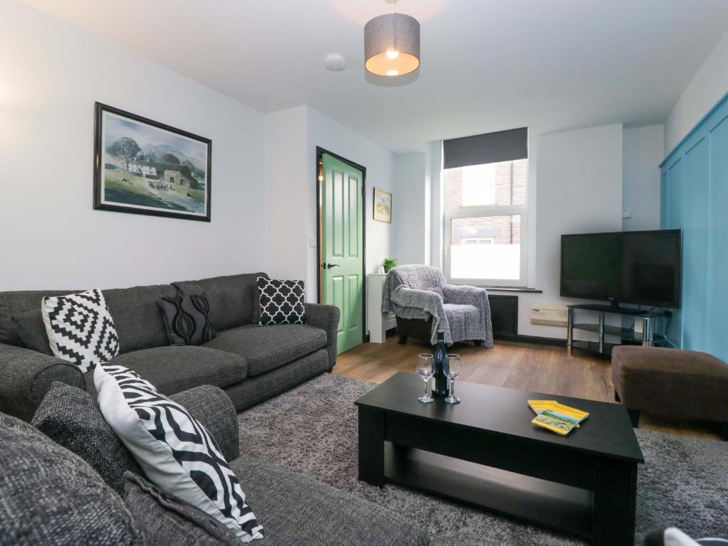 a living room with a couch and a tv at Havelock Hideaway in Windermere