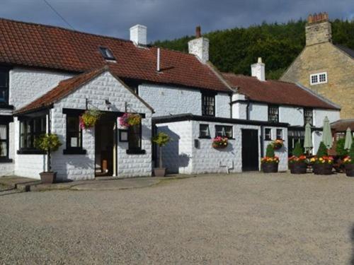 a white building with flowers in front of it at The Stapylton Arms in Wass