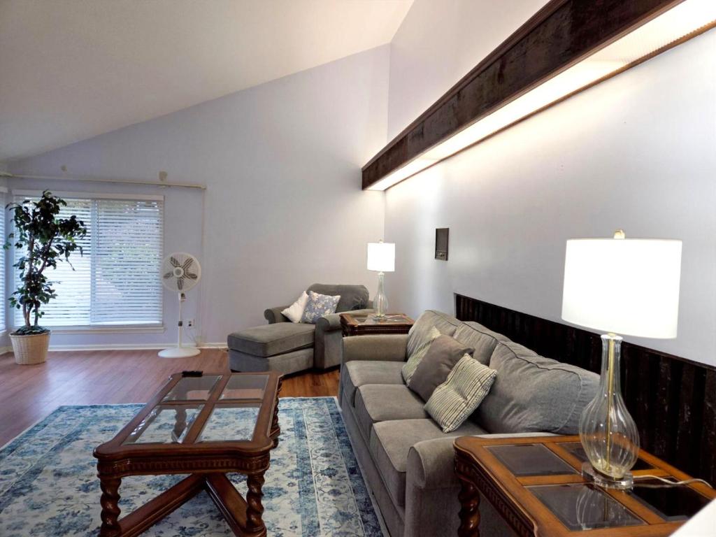 a living room with a couch and a table at Walk to Augusta National with Pool, Housekeeper, and Utilities Included in Augusta