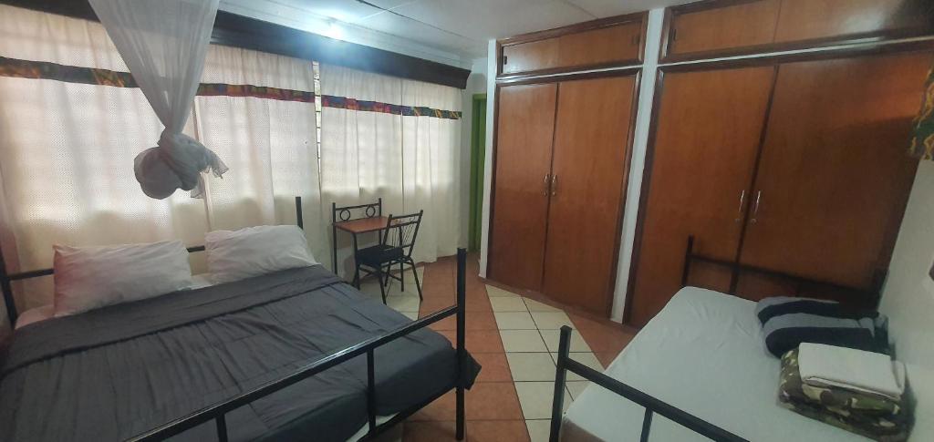 a bedroom with a bed and a window and a table at Uhuru Peak Hostel in Moshi