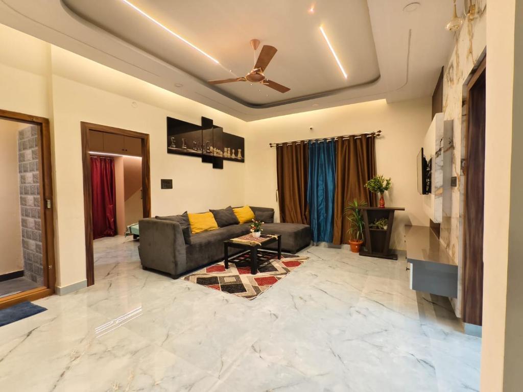 a living room with a couch and a ceiling fan at Tranquil service apartment in Chikmagalūr