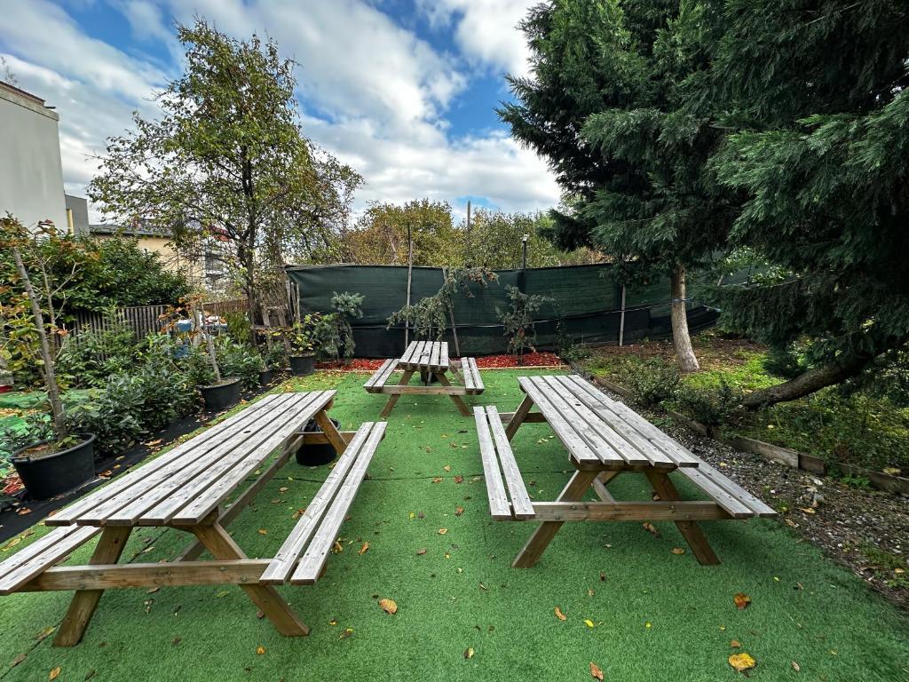 three picnic tables sitting on the grass in a yard at ANA City Rooms in Cluj-Napoca