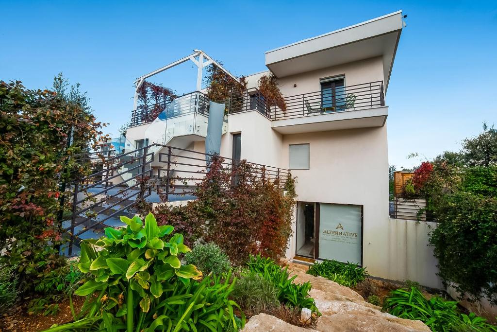 a white building with stairs and plants on it at Alternative Resort & SPA in Scorrano