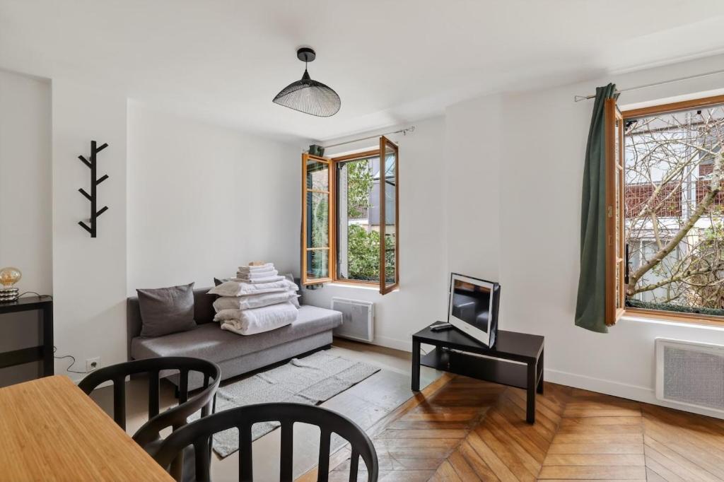 a living room with a couch and a table at Premium 1BR flat with direct access to the RER B in Gentilly