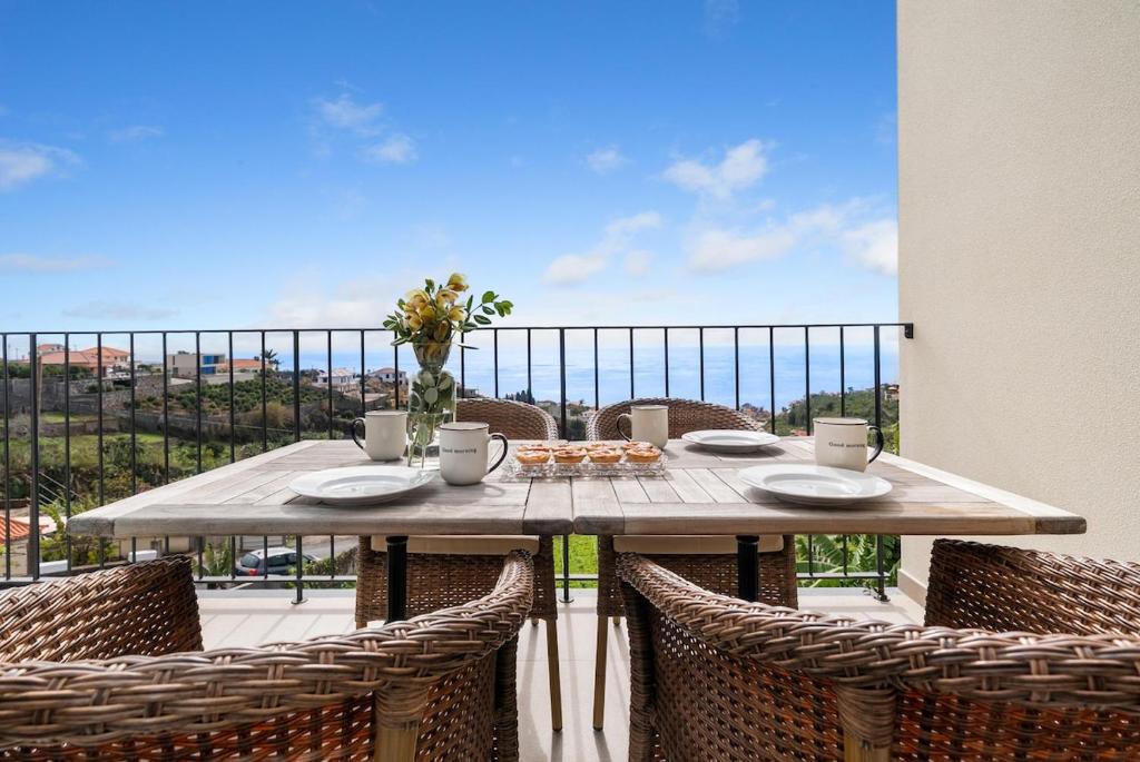 a table on a balcony with a view of the ocean at Casa da boa vista in Canhas