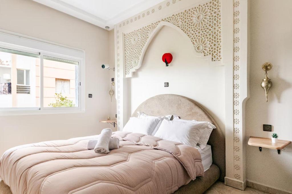 a bedroom with a large bed with a large window at Eden Appartement avec Piscine Et Salle de Sport in El Jadida