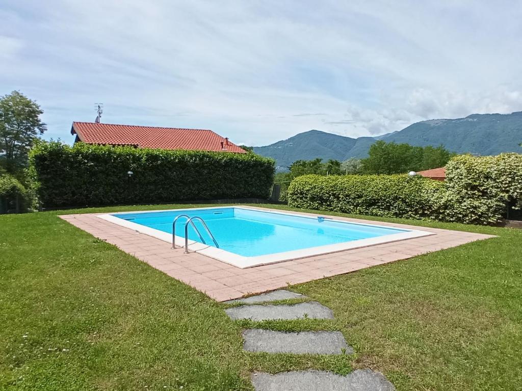 a swimming pool in the middle of a yard at Belmonte Holiday Apartment in Brezzo