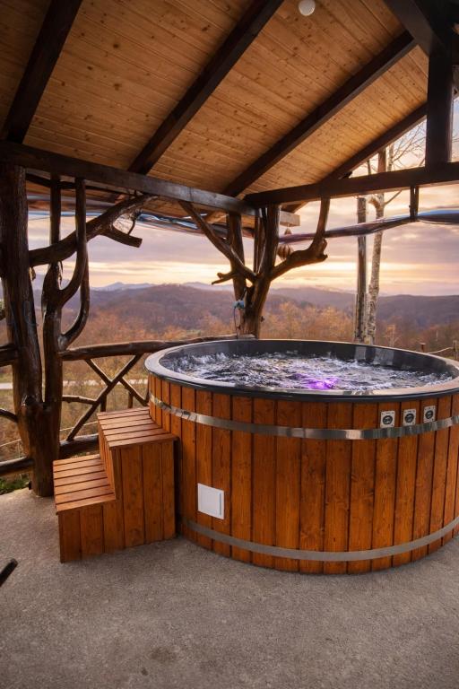 a hot tub in a wooden building with a view at Cabana Cozy cu Jacuzzi în Natură - Cabana Edera in Buninginea