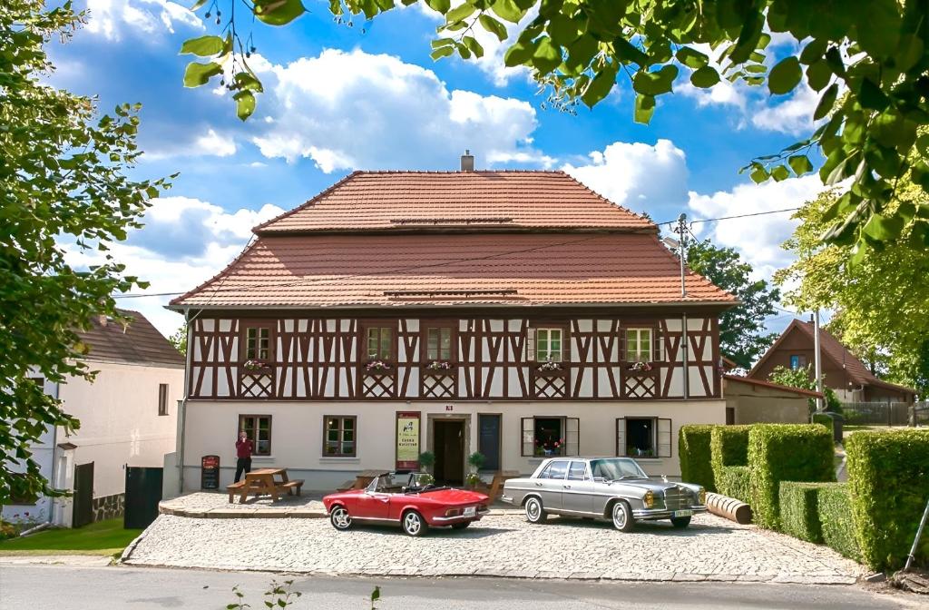 two cars parked in front of a house at U Bílého koníka in Kostelní Bříza