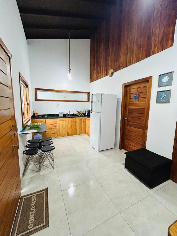 a kitchen with a refrigerator and a table and chairs at Loft 2 quartos with full kitchen in Uruçuca
