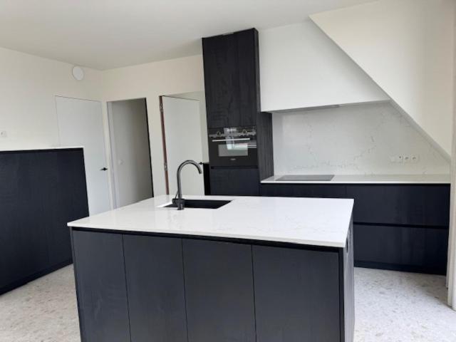 a kitchen with a sink and a counter top at The Corner -FRANS in Beernem