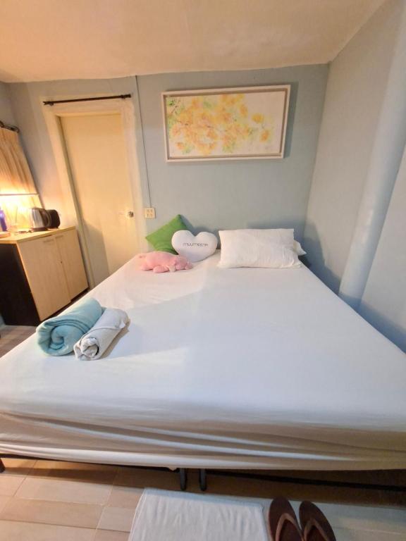 a large white bed with pillows on top of it at Budget Place Homestay-Solo Traveler in Ban Dan