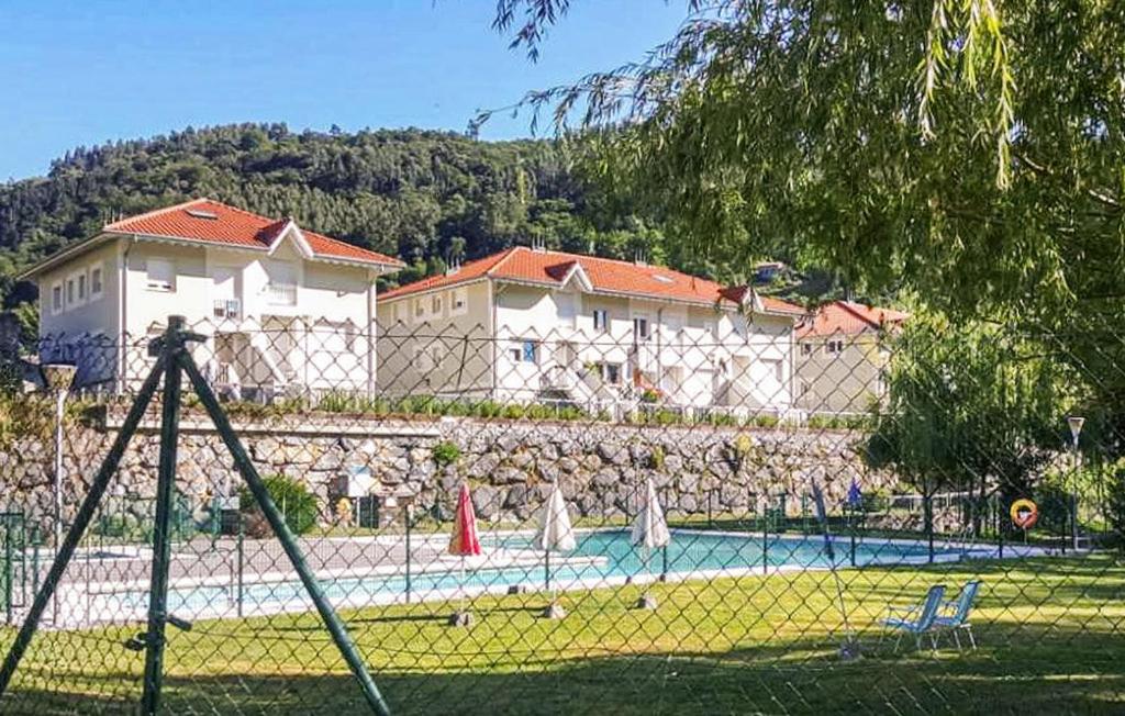 a group of people standing around a swimming pool at Chalet adosado con piscina en el Valle de Asón LA TUDANCA in Arredondo