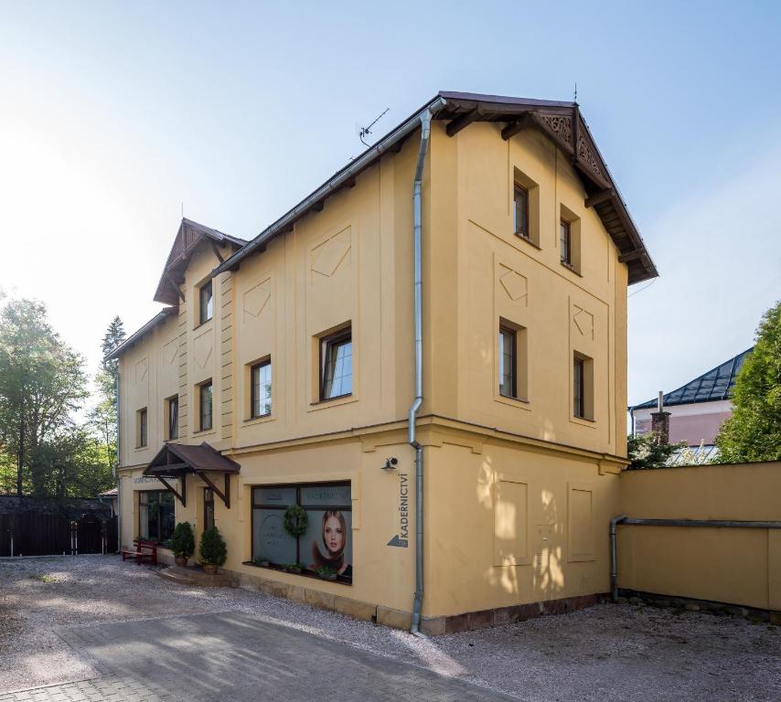 a yellow building with a sign on the side of it at Apartmány U Parku in Vrchlabí