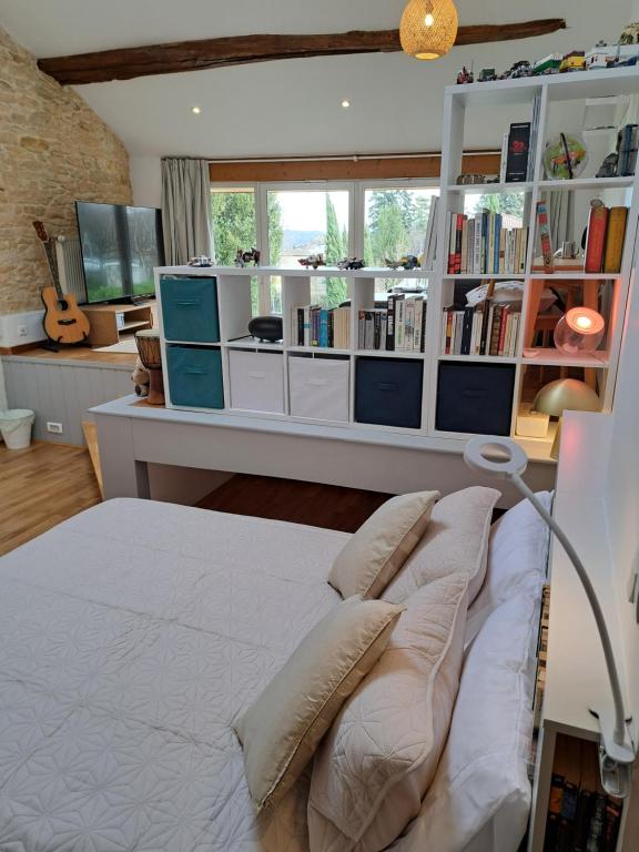 a bedroom with a bed and a desk with books at L'estrade des Alpes 45m2 petit-déjeuner inclus in Saint-Alban-de-Roche